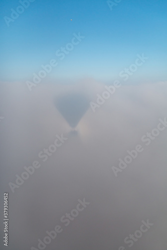 Balloon shadow in the cloud with a small rainbow around