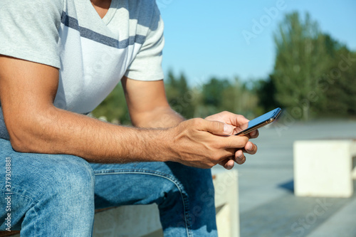 Man using modern mobile phone outdoors, closeup