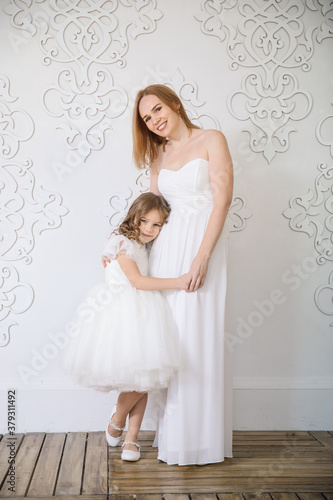 mom and daughter in white evening dresses. family celebration. maternal love. mother's day.