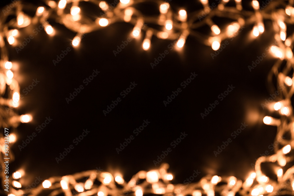 Blurry christmas lights. Christmas lights border. Christmas background with lights and free text space. Christmas lights on black background.