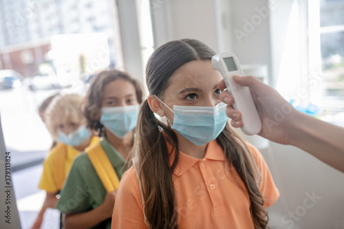 Children passing temperature control while entering the school