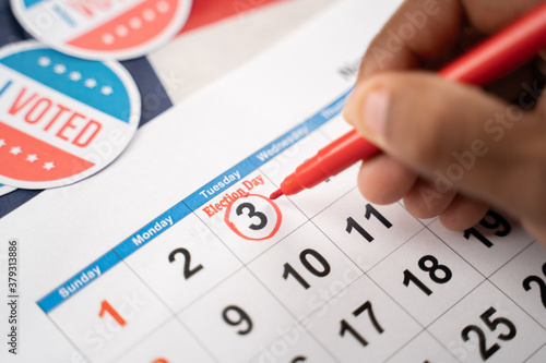 Close up of Hands marking november 3 election day on Calendar as reminder for voting - Concept of reminder for US election. photo