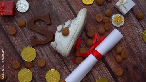 Dutch holiday Sinterklaas background. Rotation children shoe, carrots for Santa's horse, gifts, traditional sweets pepernoten and chocolate letter. Schoentje zetten concept. 4k video photo