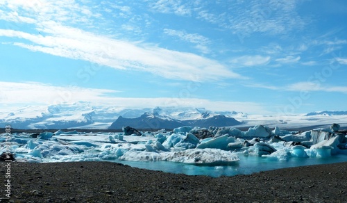 Beautiful glacial lagoon Jokulsarlon in Iceland.Beautiful white winter landscape. Snow covered mountains. Natural northern wonder. Sparkling blue ice floes on shore. 