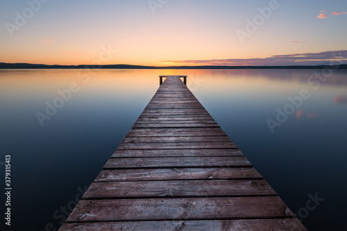 Old wooden pier at sunset. Long exposure  linear perspective