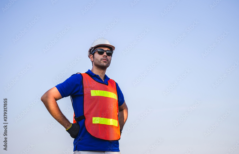 Factory worker man standing on container box and looking to the sky