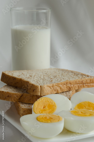 Sliced Whole Wheat Bread, Boiled Egg and Milk for Breakfast.