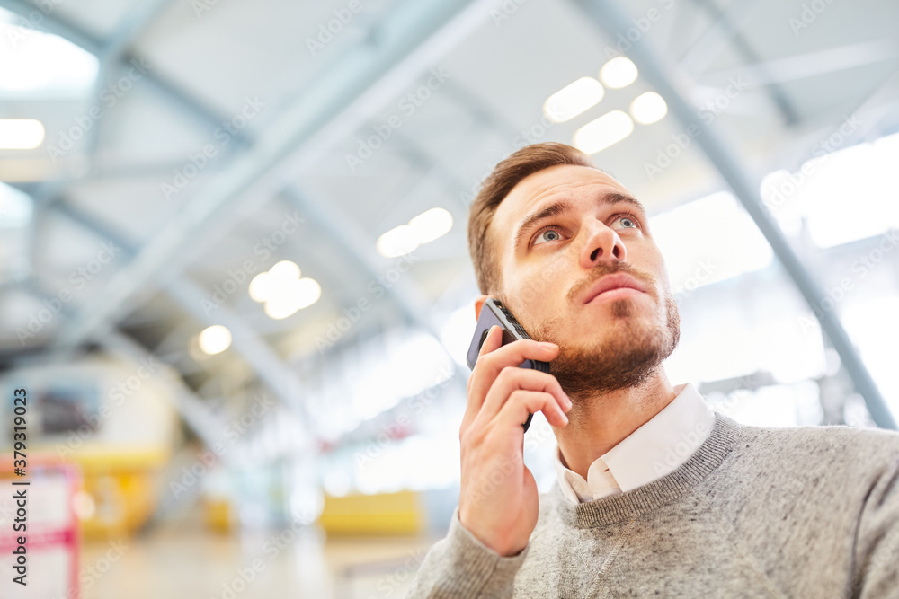 Reisender telefoniert mit Smartphone im Flughafen Reisender telefoniert mit Smartphone im Flughafen