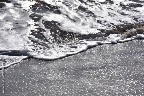 Bright wave reaching the beach sand