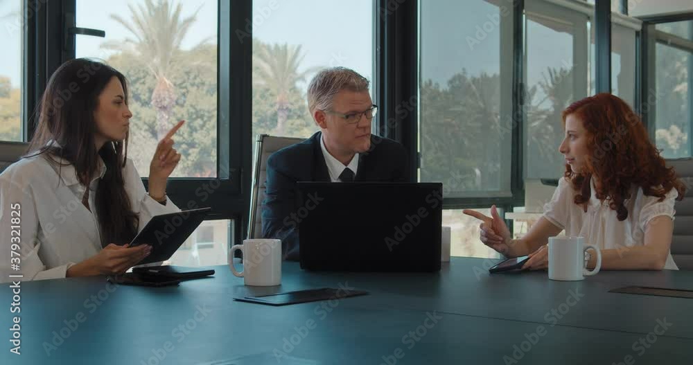 The creative business team of three people discussing a new project. Business meeting, working together, sharing ideas concept. Slow motion. The creative business team of three people discussing a new project. Business meeting, working together, sharing ideas concept. Slow motion.