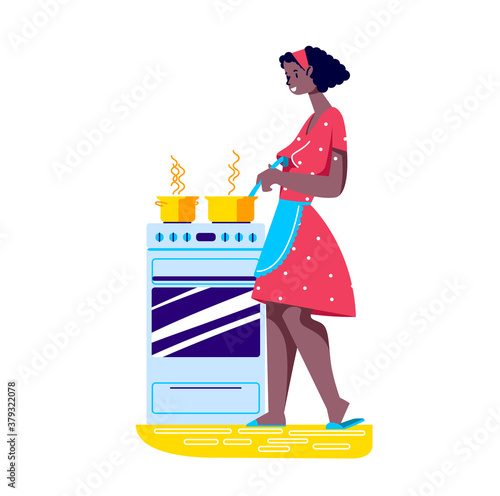 Young woman in apron standing at cooking stove preparing dinner or supper for family