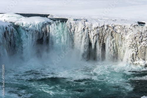 Scenic winter view of Godafoss waterfall in Iceland. Picturesque winter landscape with frozen waterfall in Iceland.