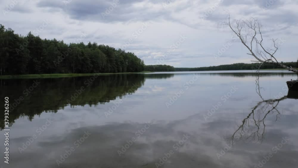 Beautiful Nature Reflections Of Serene Lake On A Cloudy Day In Pradzonka, Northern Poland - Wide Shot Beautiful Nature Reflections Of Serene Lake On A Cloudy Day In Pradzonka, Northern Poland - Wide Shot