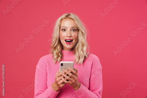 Image of surprised beautiful woman using mobile phone