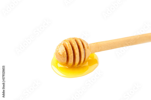 Drops of honey and dipper isolated on white background.