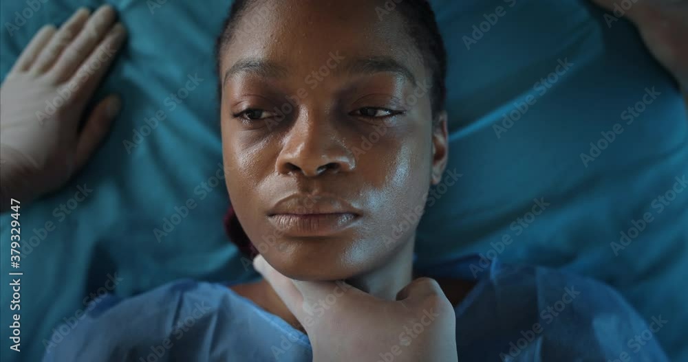 Close up of paramedics take off oxygen inhalation mask from afro american girl face. Young woman dying while lying on medical transportation stretcher while going to hospital Close up of paramedics take off oxygen inhalation mask from afro american girl face. Young woman dying while lying on medical transportation stretcher while going to hospital