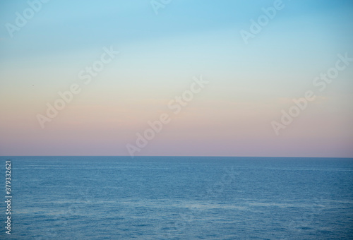 Gentle pastel sunset over the calm surface of the sea. © FO_DE