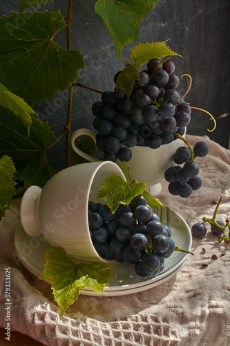 Grapes on a white saucer and a dark background.