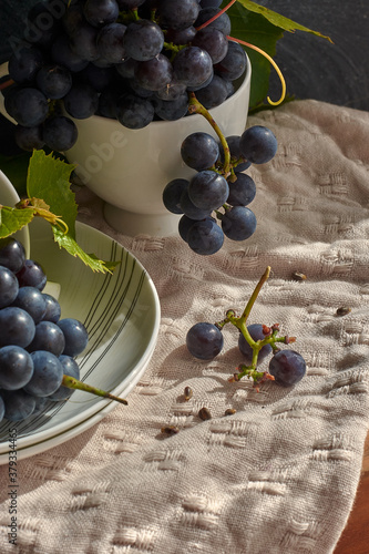 Grapes on a white saucer and a dark background.