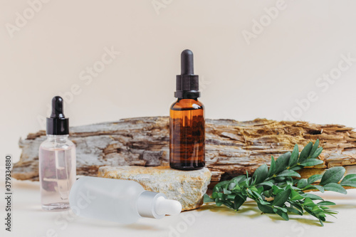 Three bottles with droppers of cosmetic liquid, hyaluronic acid or serum for natural skin care. The trend of natural cosmetics made from bio components. Place for text