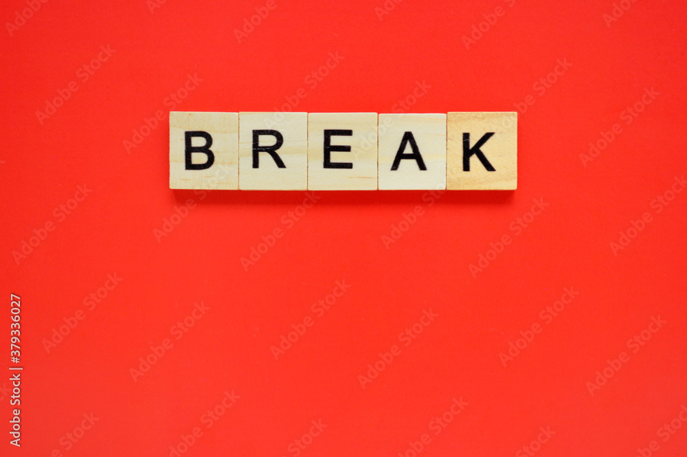 Word break. Wooden blocks with lettering on top of red background. Top view of wooden blocks with letters on red surface Word break. Wooden blocks with lettering on top of red background. Top view of wooden blocks with letters on red surface