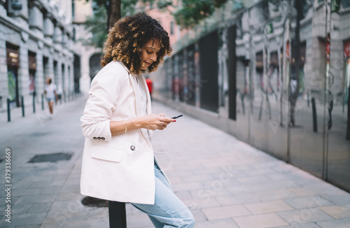 Young stylish woman using smartphone on street