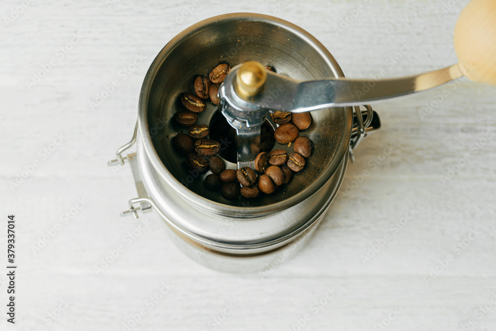 Some coffee beans in a metallic coffee grinder