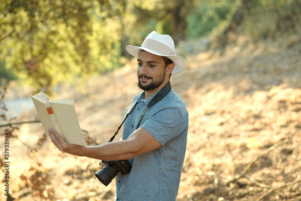 Photographer consults picture book while holding camera Photographer consults picture book while holding camera