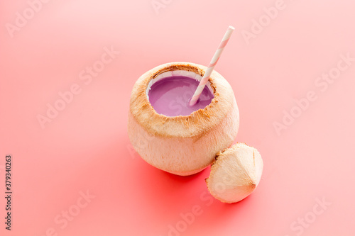 Raw coconut cocktail with drinking straw, top view
