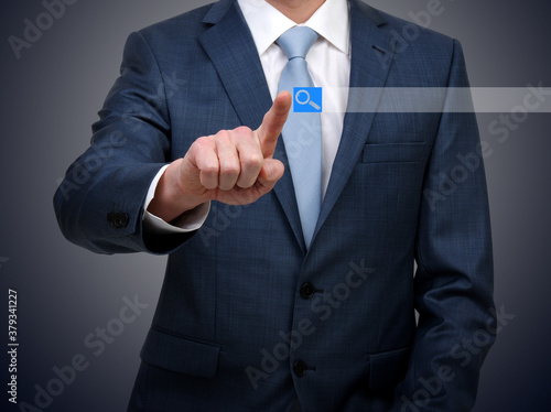 Businessman in suit touching virtual button
