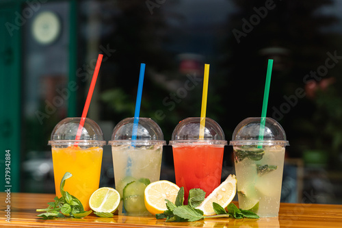 Assortment of seasonal summer cocktails in plastic glasses to go