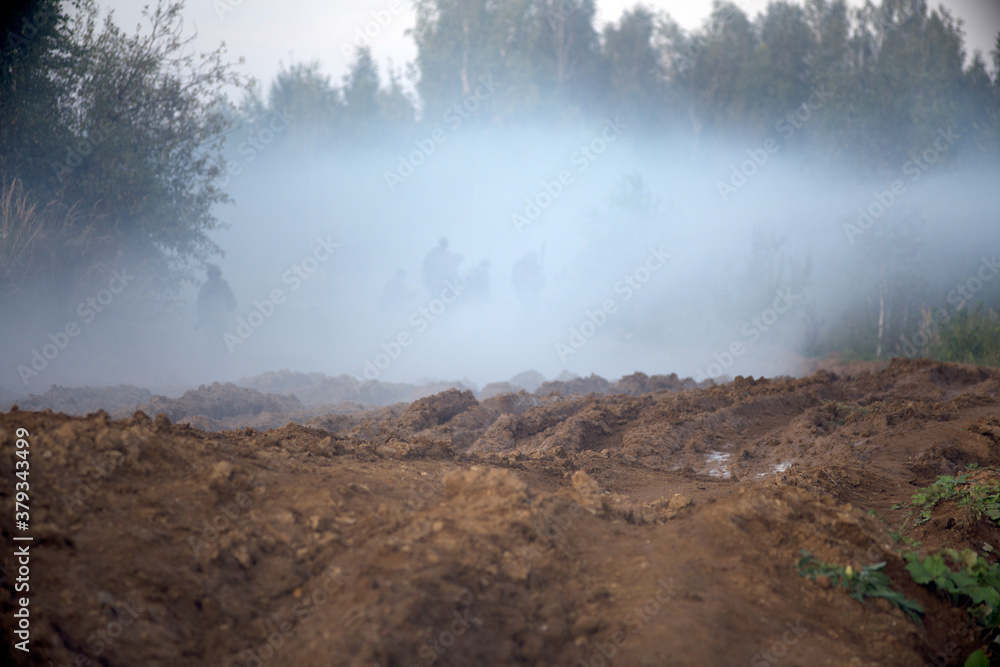Smoke bombs action. A group of soldiers on a field position.