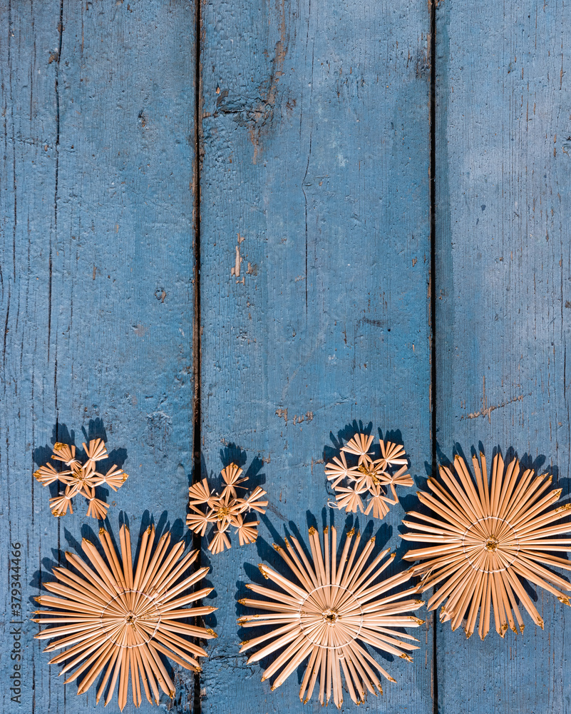Wooden Christmas background, top view. Place for text on a new year's background. Beautiful blue Christmas background with handmade straw Christmas tree toys and snowflakes.