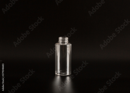 Clean white and transparent plastic container of different sizes on a black background. Packaging, bottle for cosmetics, antiseptics, detergents and chemical cleaning products for medical and cosmetic