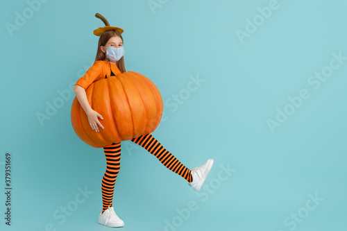 girl in pumpkin costume  wearing face mask