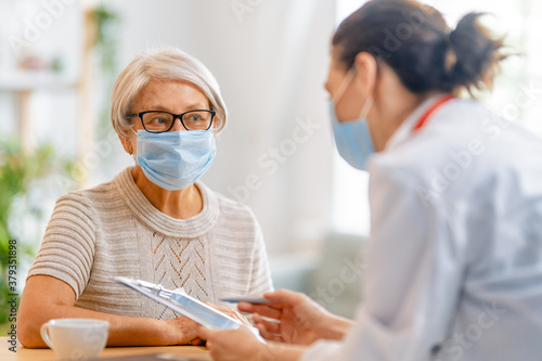 Doctor and senior woman wearing facemasks