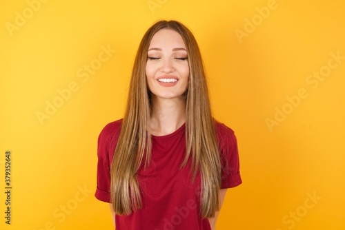 Beautiful Young beautiful caucasian girl wearing red t-shirt over isolated yellow background very happy and excited about new plans. © Roquillo