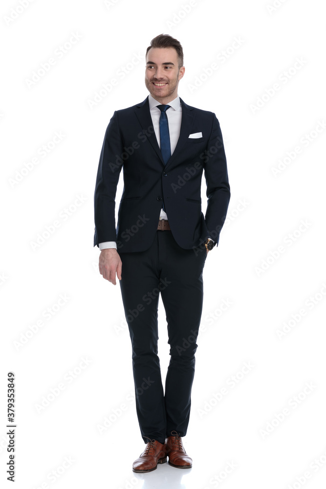 Charming businessman smiling and looking away with hand in pocket Charming businessman smiling and looking away with hand in pocket