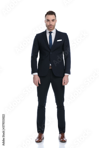 Serious businessman looking forward and wearing suit while standing