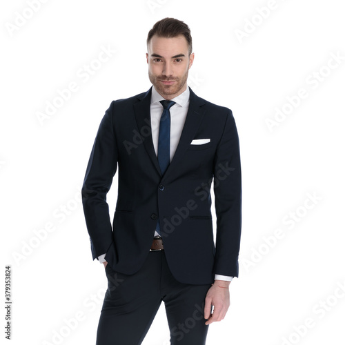 Charming businessman looking forward with hand in pocket
