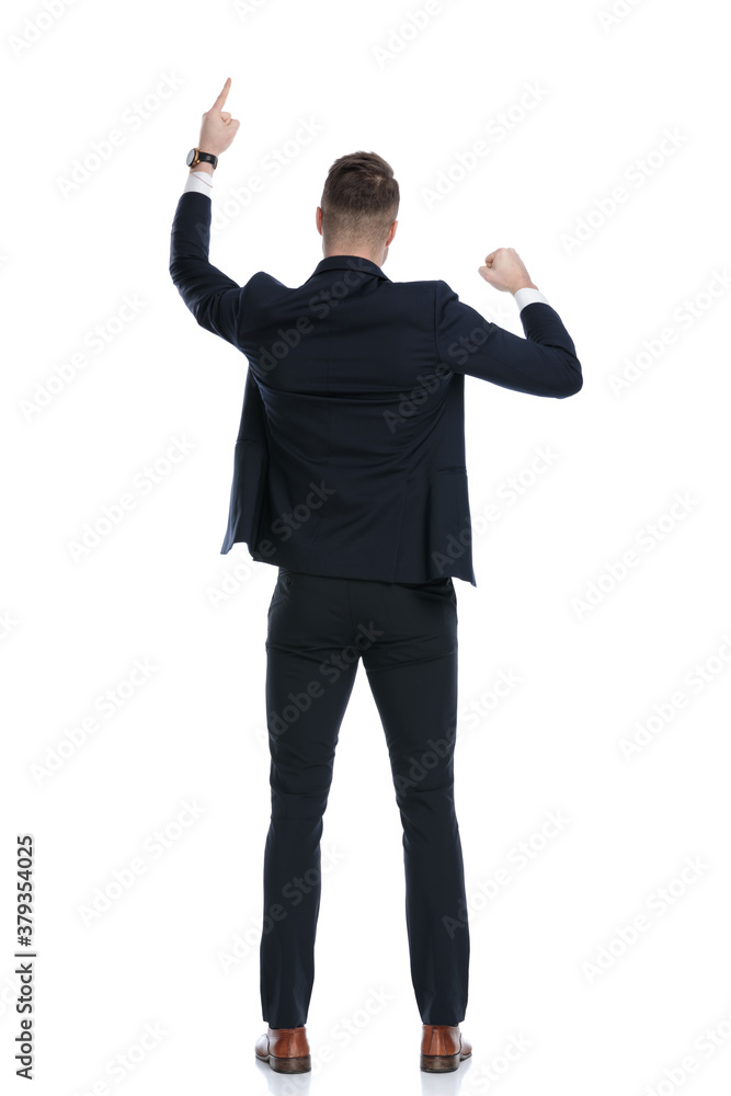 Back view of businessman pointing up and celebrating Back view of businessman pointing up and celebrating