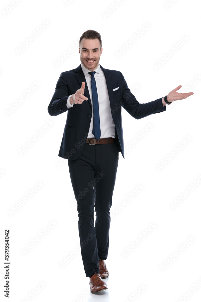 Smiling businessman pointing and presenting while walking Smiling businessman pointing and presenting while walking
