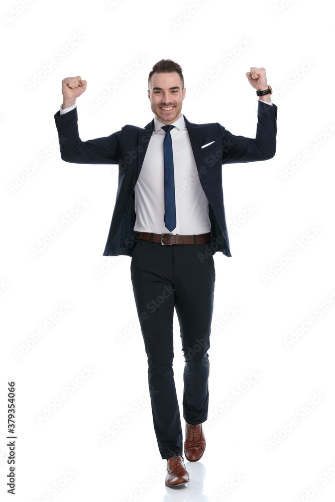 Smiling businessman celebrating with both fists in the air Smiling businessman celebrating with both fists in the air