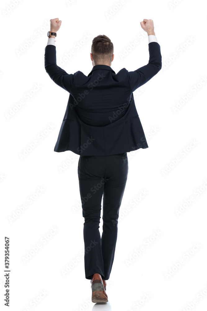Rear view of happy businessman celebrating while walking Rear view of happy businessman celebrating while walking