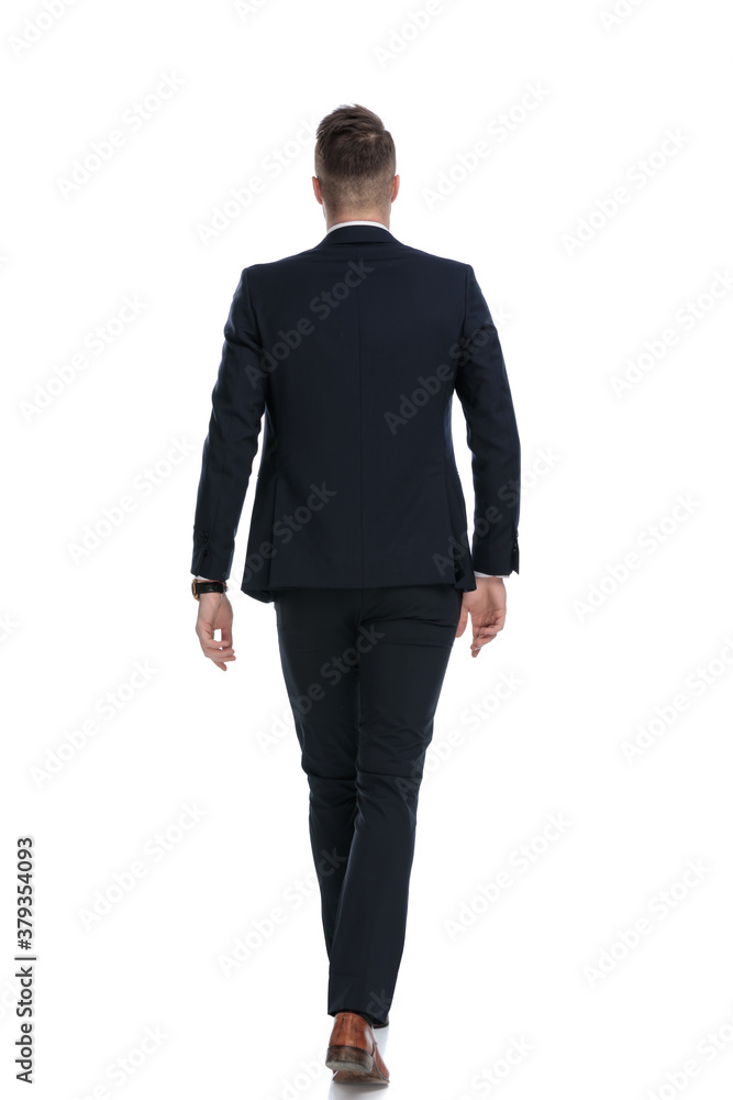 Rear view of young businessman wearing suit and walking Rear view of young businessman wearing suit and walking
