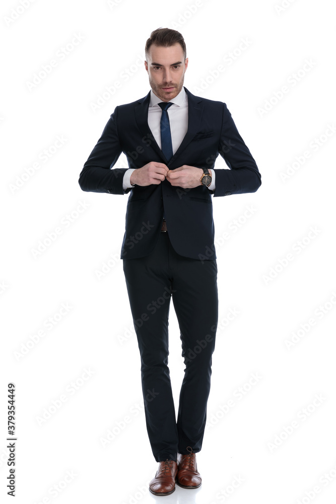 Confident businessman unbuttoning jacket while stepping Confident businessman unbuttoning jacket while stepping