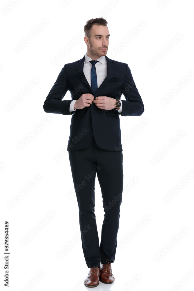 Serious businessman fixing his jacket and looking away Serious businessman fixing his jacket and looking away