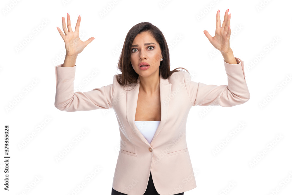 Scared businesswoman freezing with hands in the air Scared businesswoman freezing with hands in the air