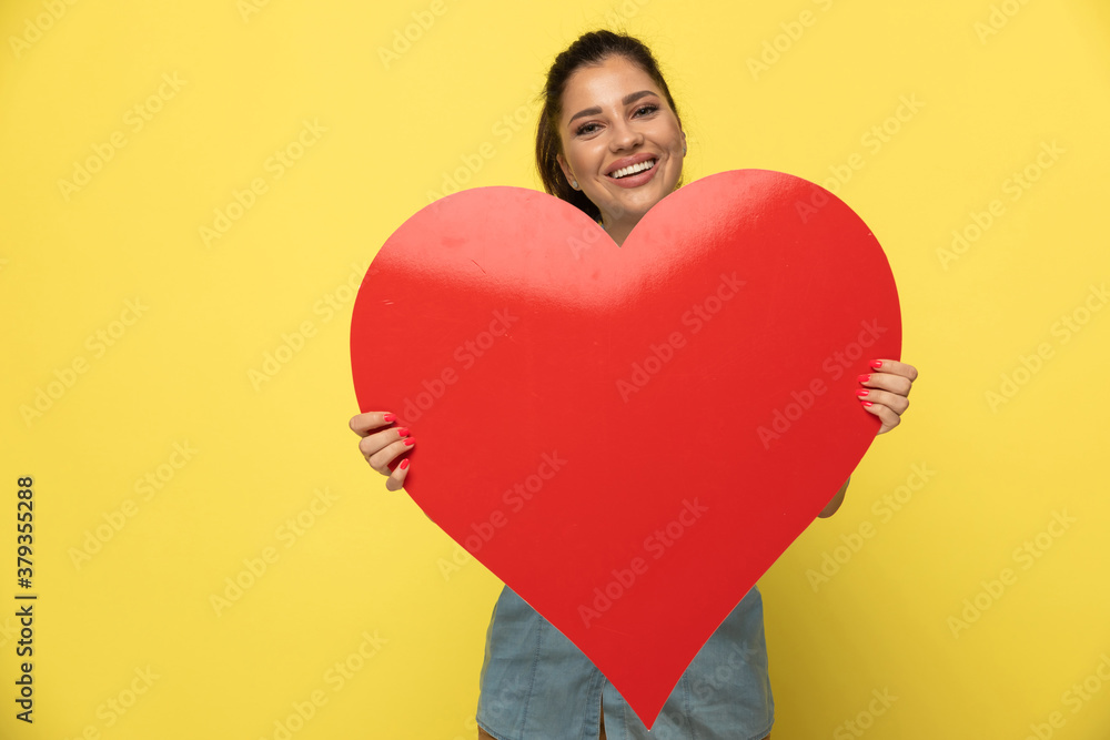 Happy casual woman holding heart shape and laughing Happy casual woman holding heart shape and laughing