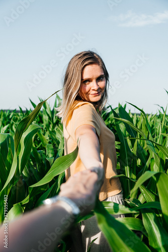 young woman in a corn field in a yellow t-shirt with a place under the text with short hair